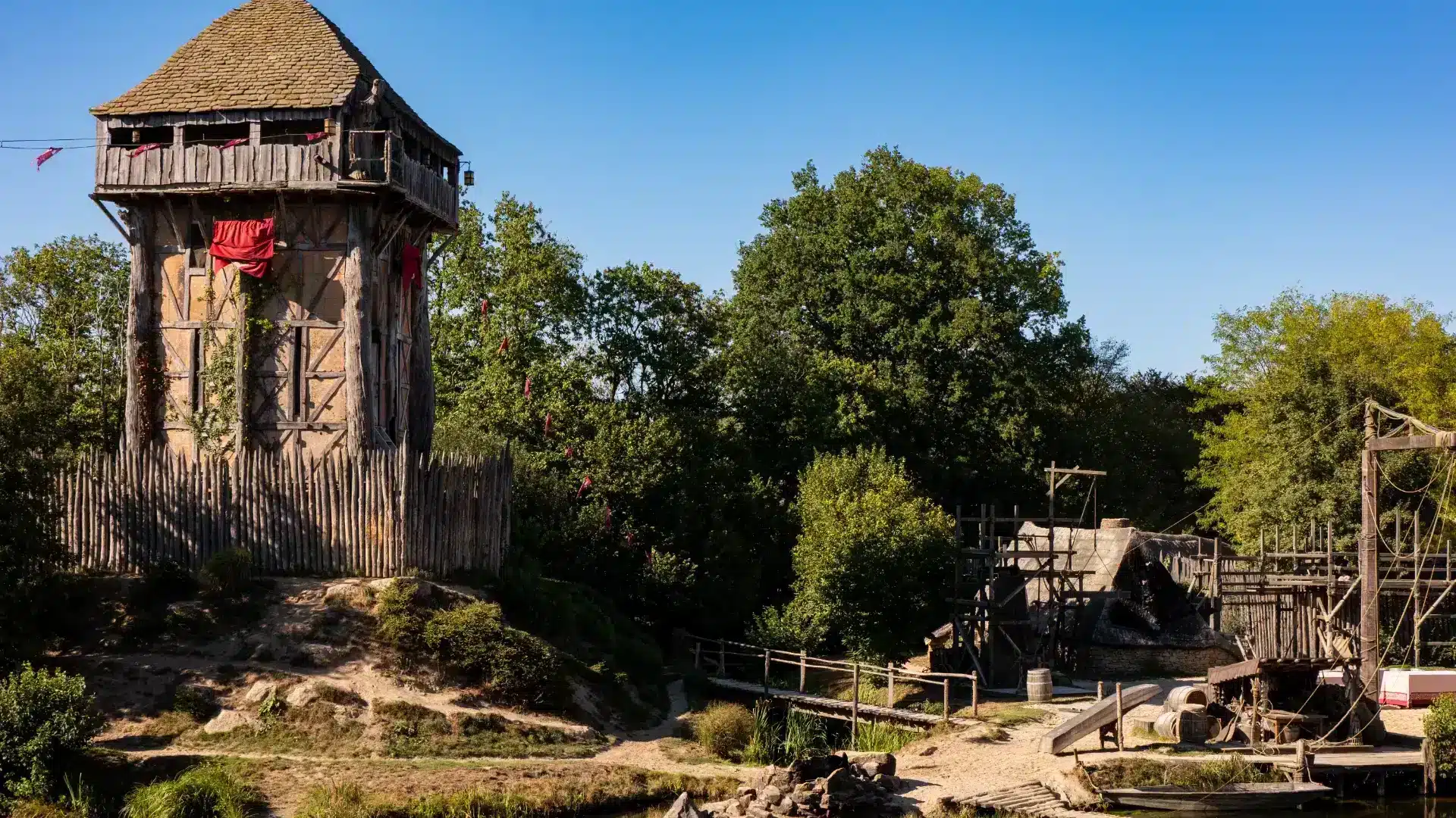Tour médiévale en bois près d'un lac.