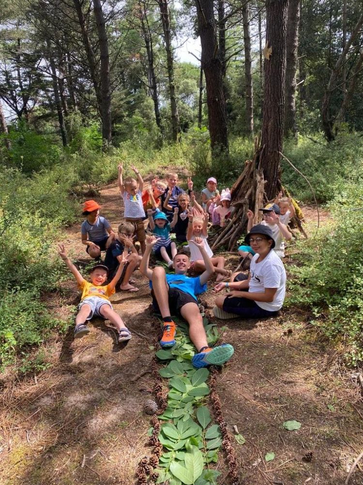 Enfants jouent dans la forêt autour d'un arbre.