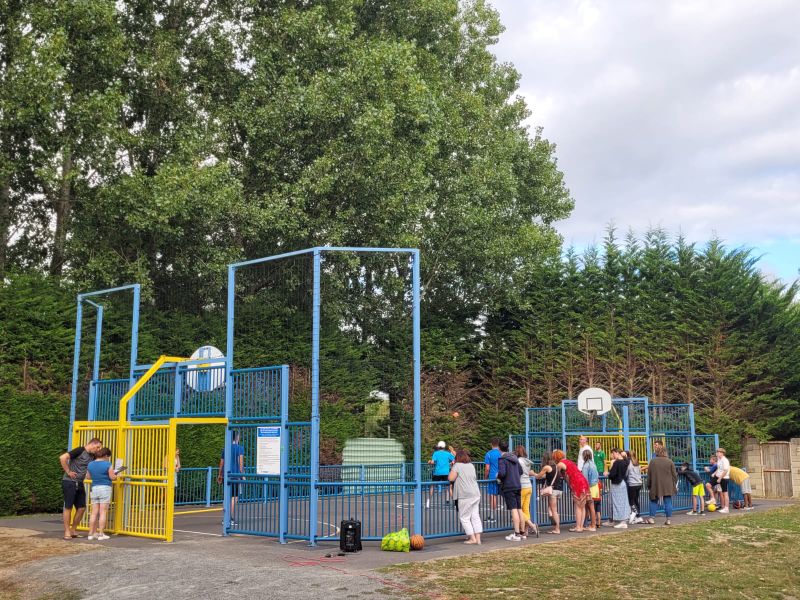 Groupe de personnes autour d'un terrain de sport