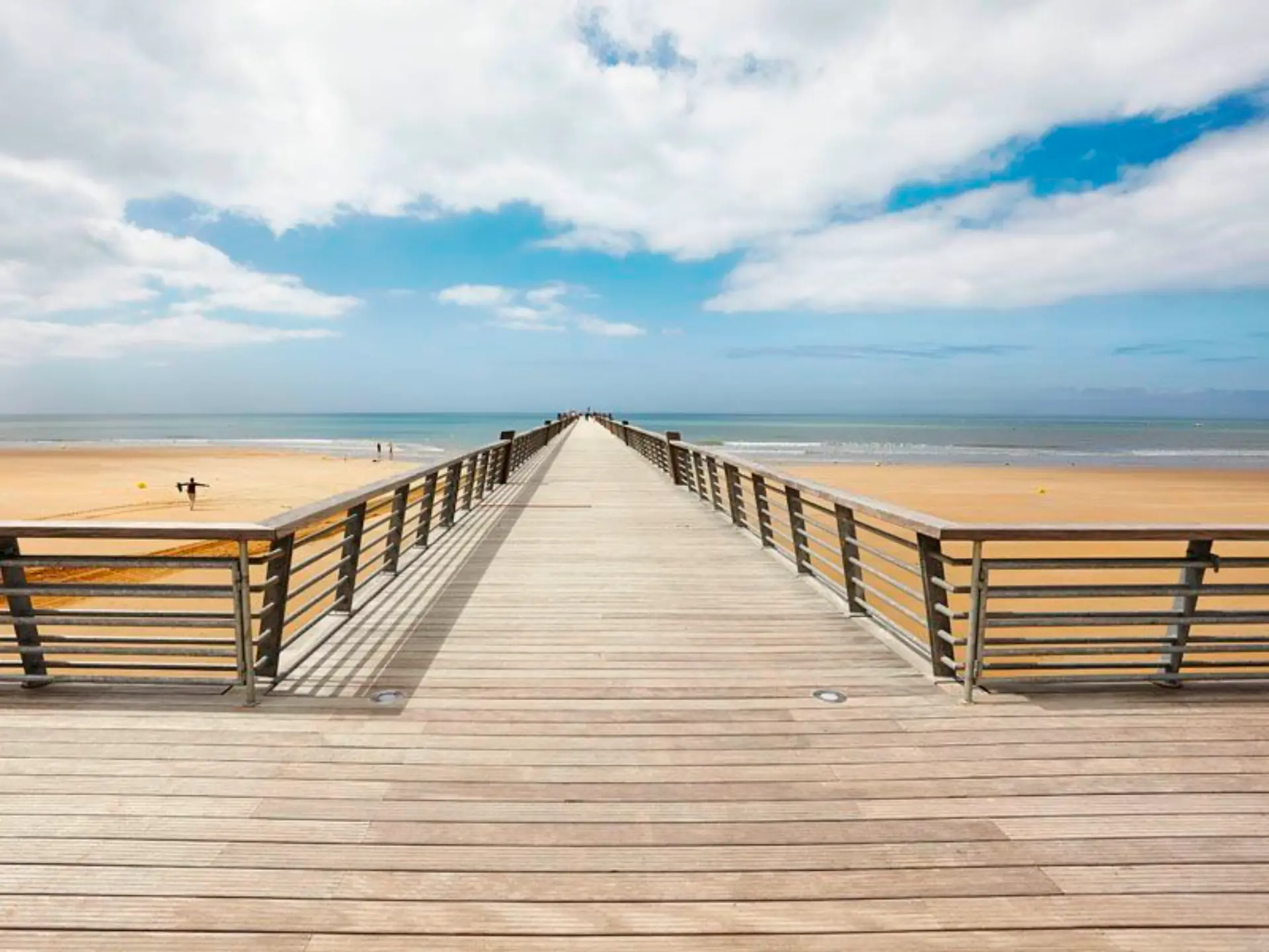 Ponton en bois vers plage et océan.
