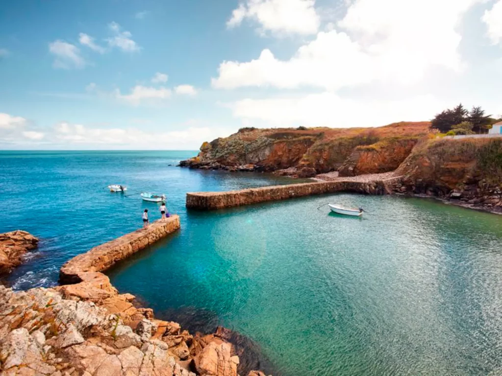 Petite baie avec pontons et barques, ciel bleu.