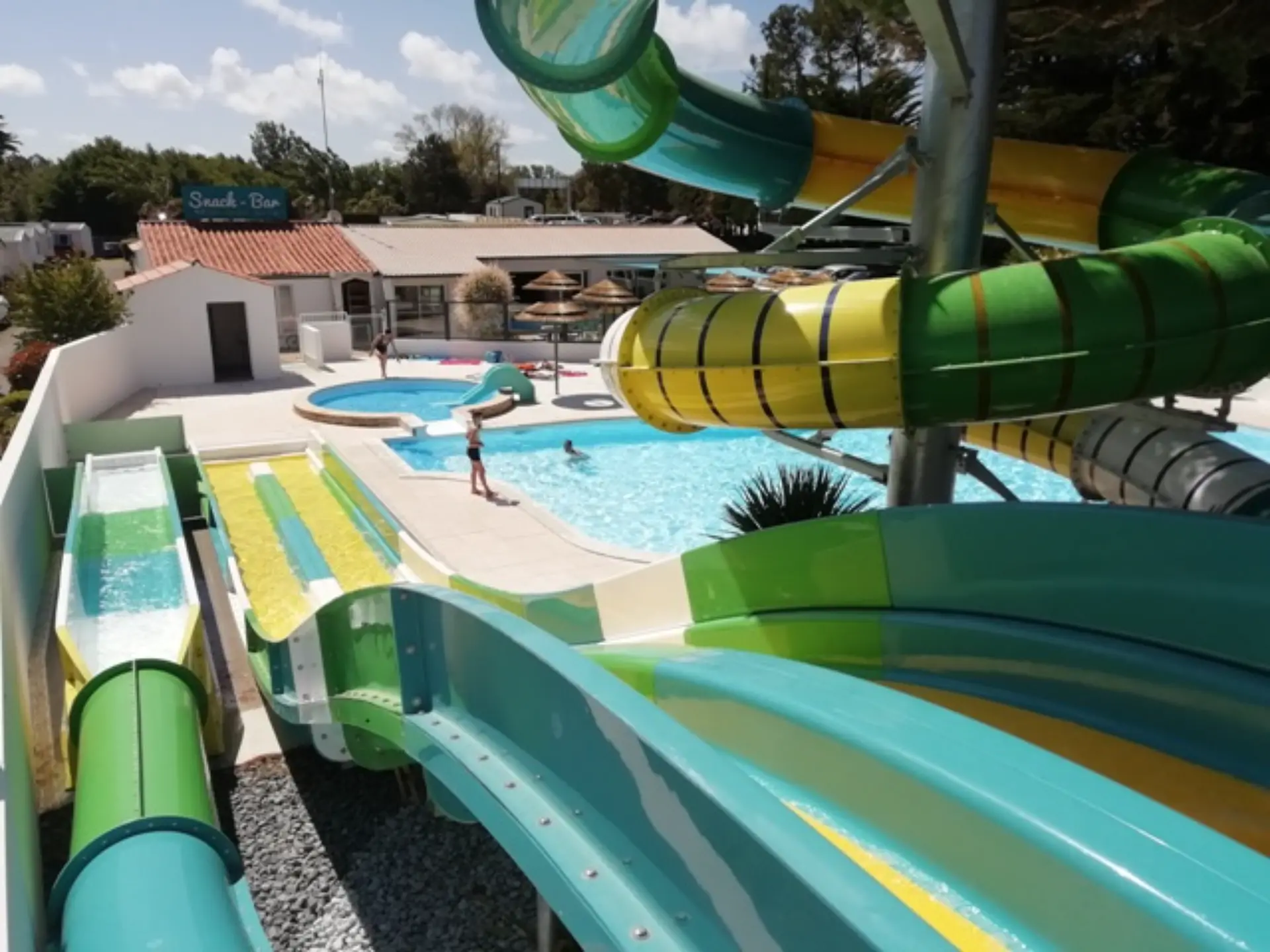 Piscine avec toboggans colorés dans un parc aquatique.