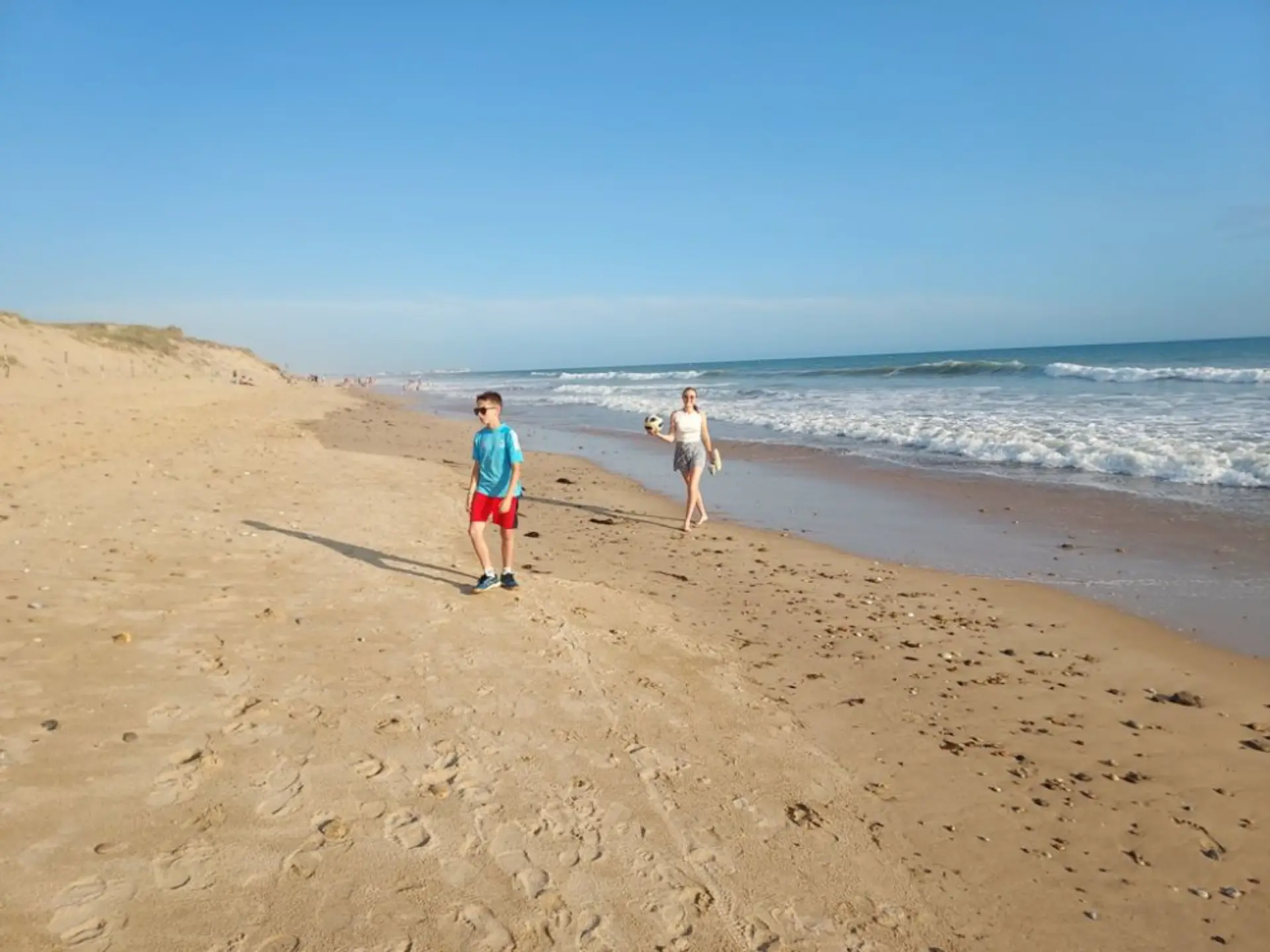 Enfants marchant sur la plage ensoleillée