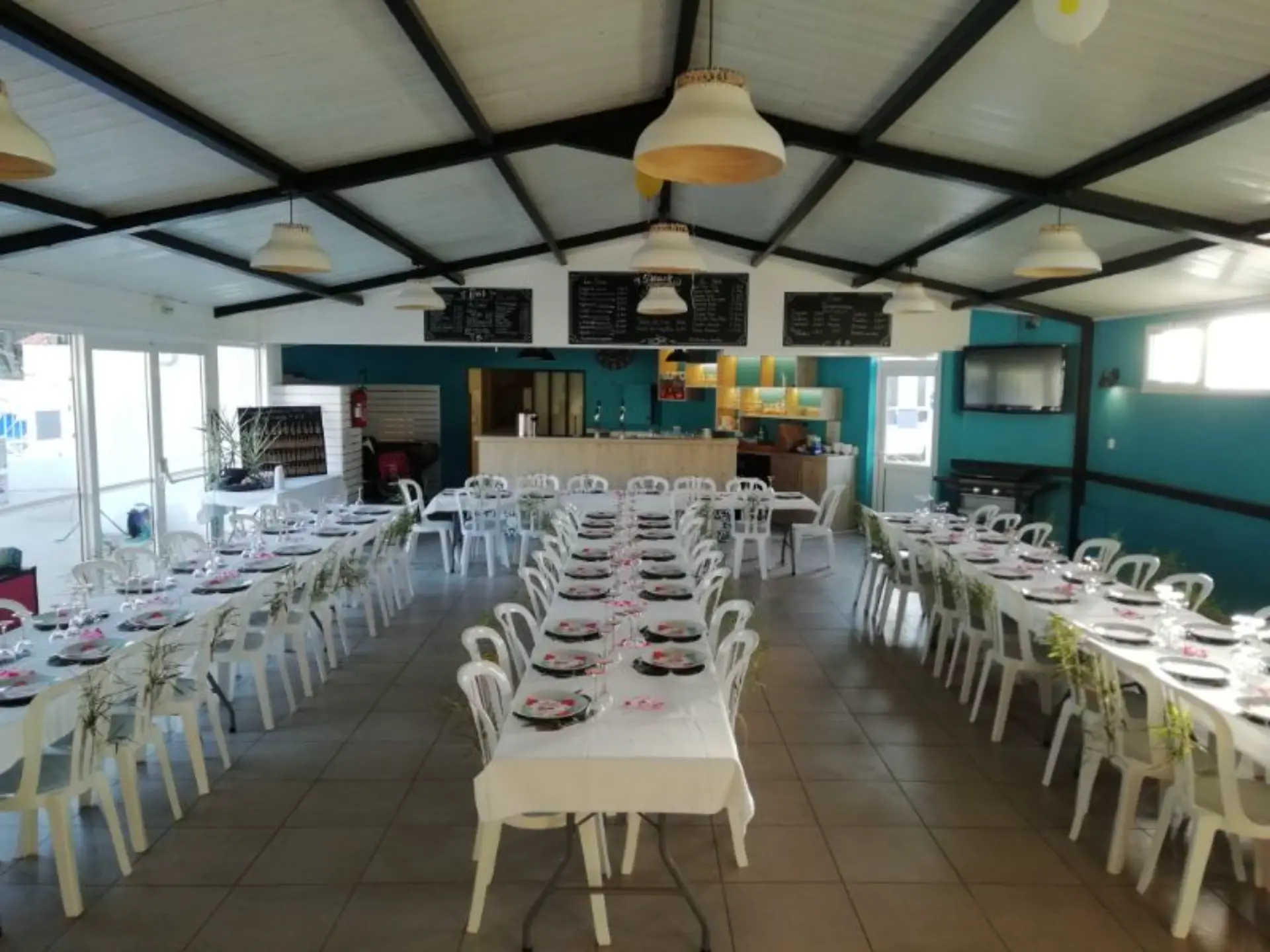 Salle de réception avec tables préparées pour banquet.