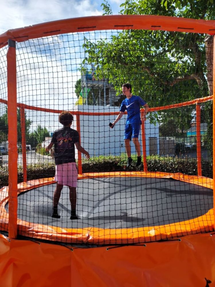 Enfants jouant sur un trampoline en plein air.