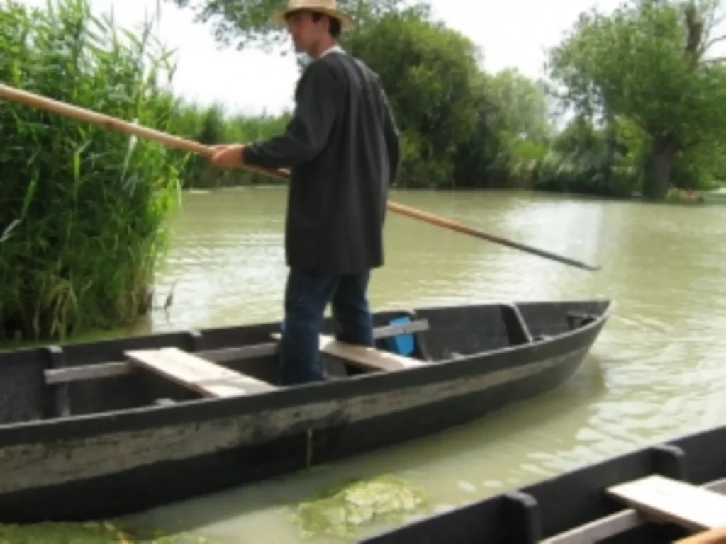 Homme naviguant sur une barque en rivière verdoyante.