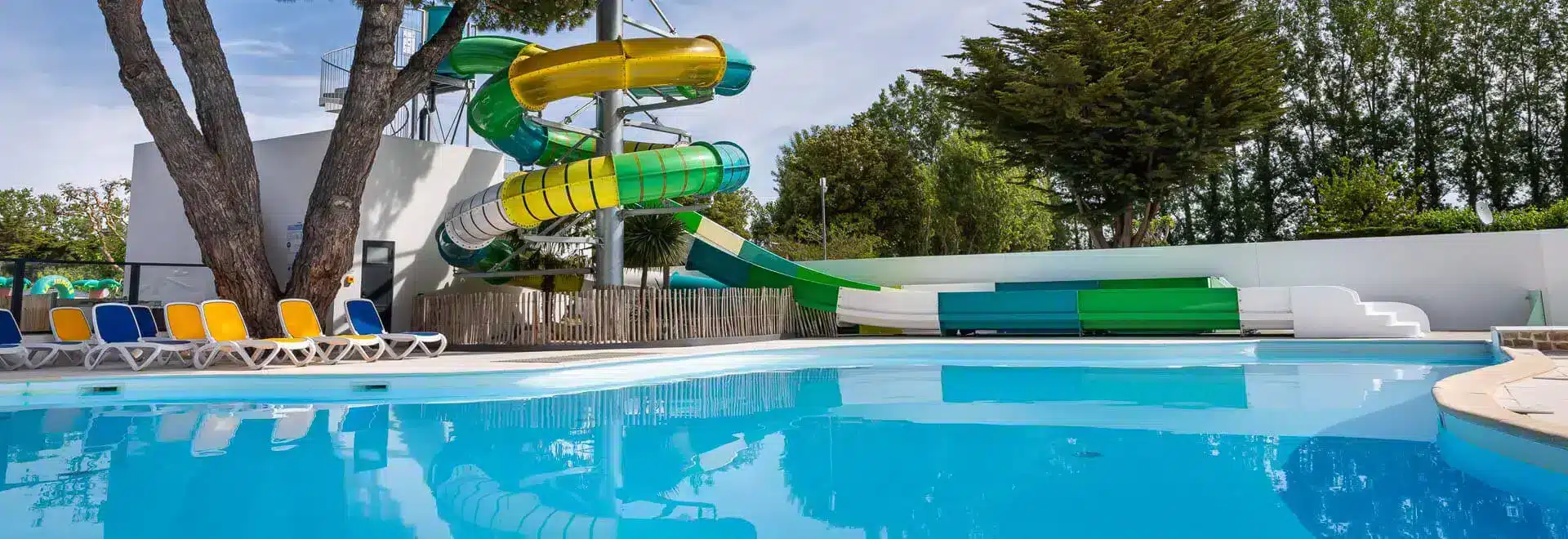 Piscine et toboggans colorés dans un parc aquatique.