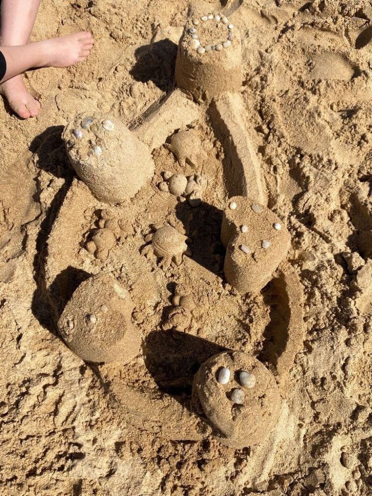 Château de sable avec coquillages sur la plage.