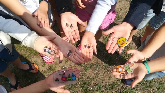 Enfants montrant des porte-clés colorés dans leurs mains.