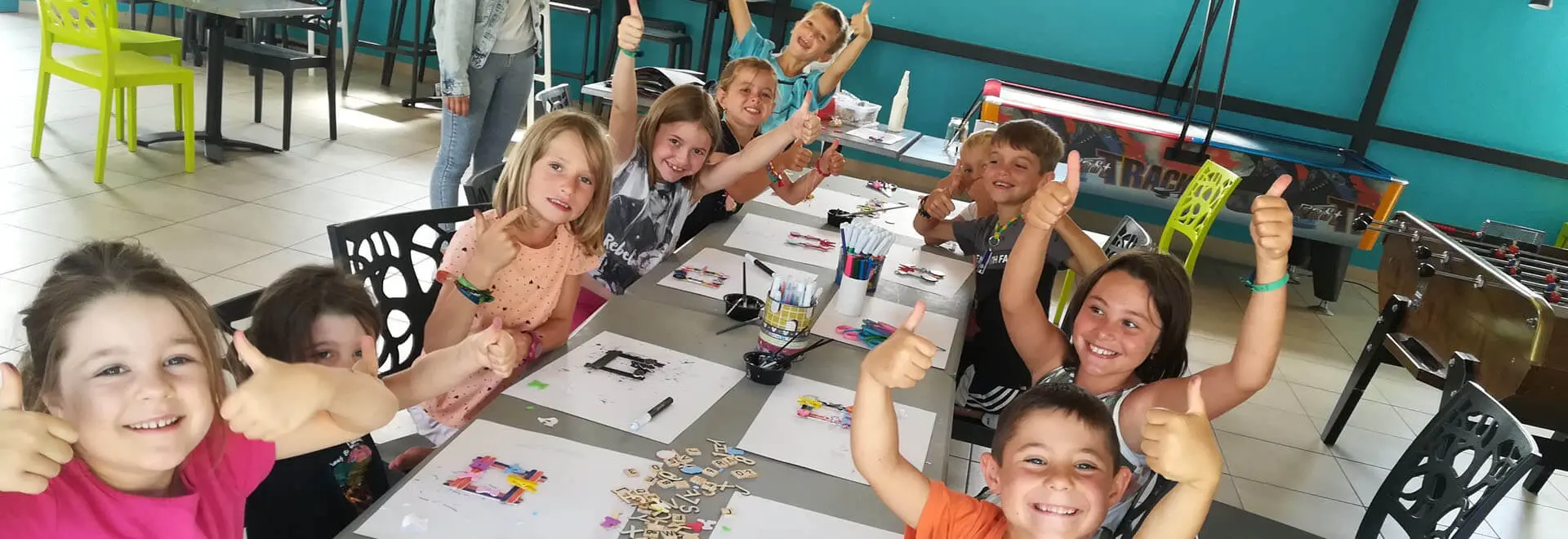 Enfants heureux levant le pouce en classe d'art.