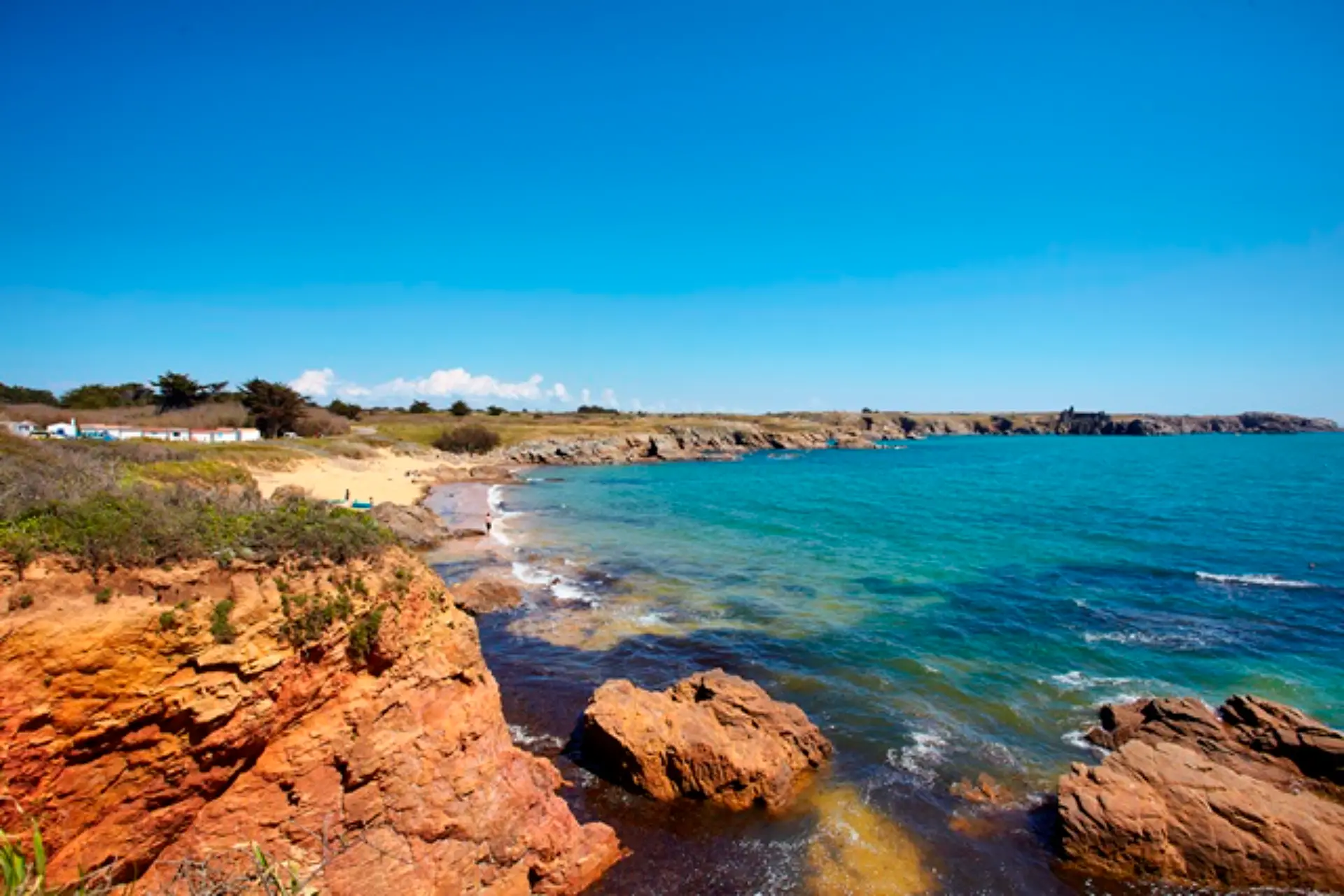 Côte rocheuse et mer bleue près de la plage.