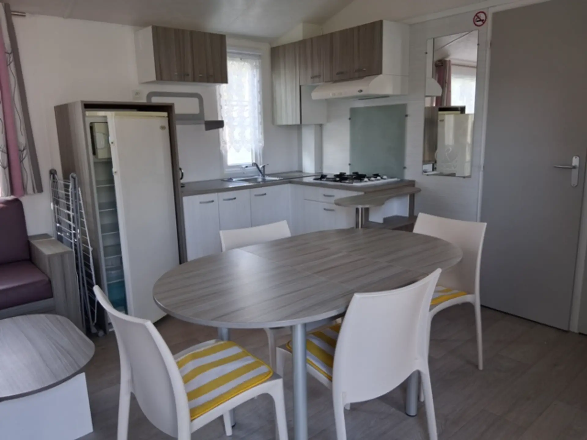 Cuisine moderne avec table ronde et chaises blanches.