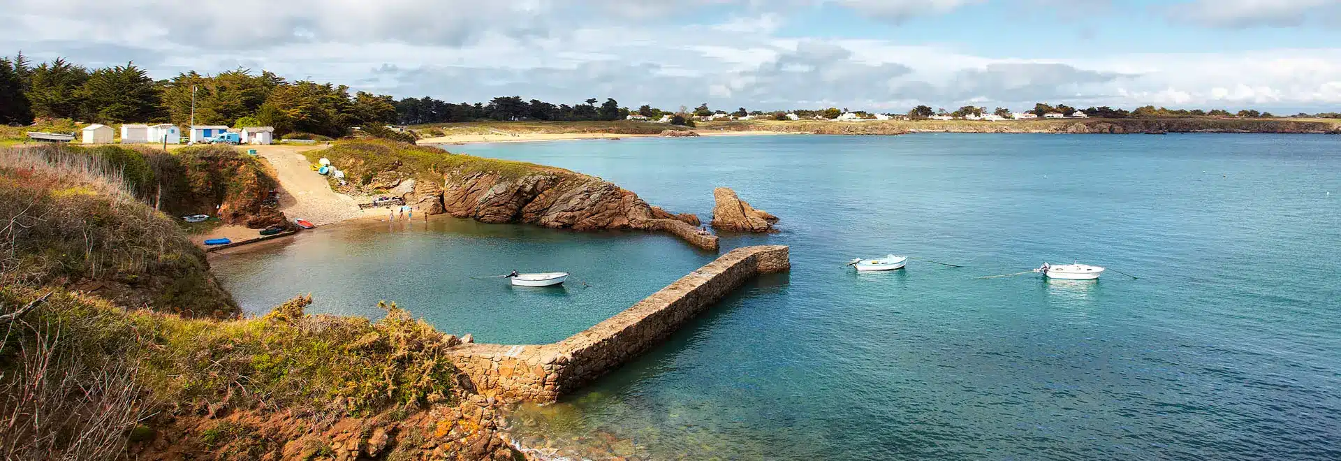 Port pittoresque avec bateaux et plage rocheuse