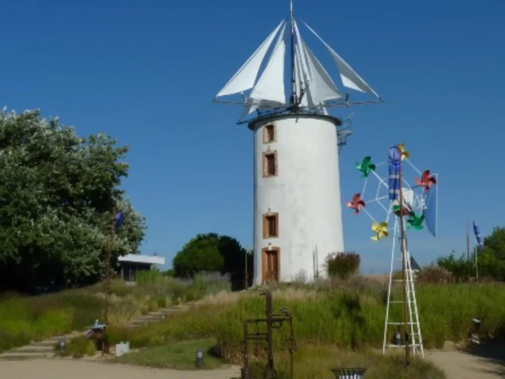 Moulin à vent blanc avec girouette colorée.
