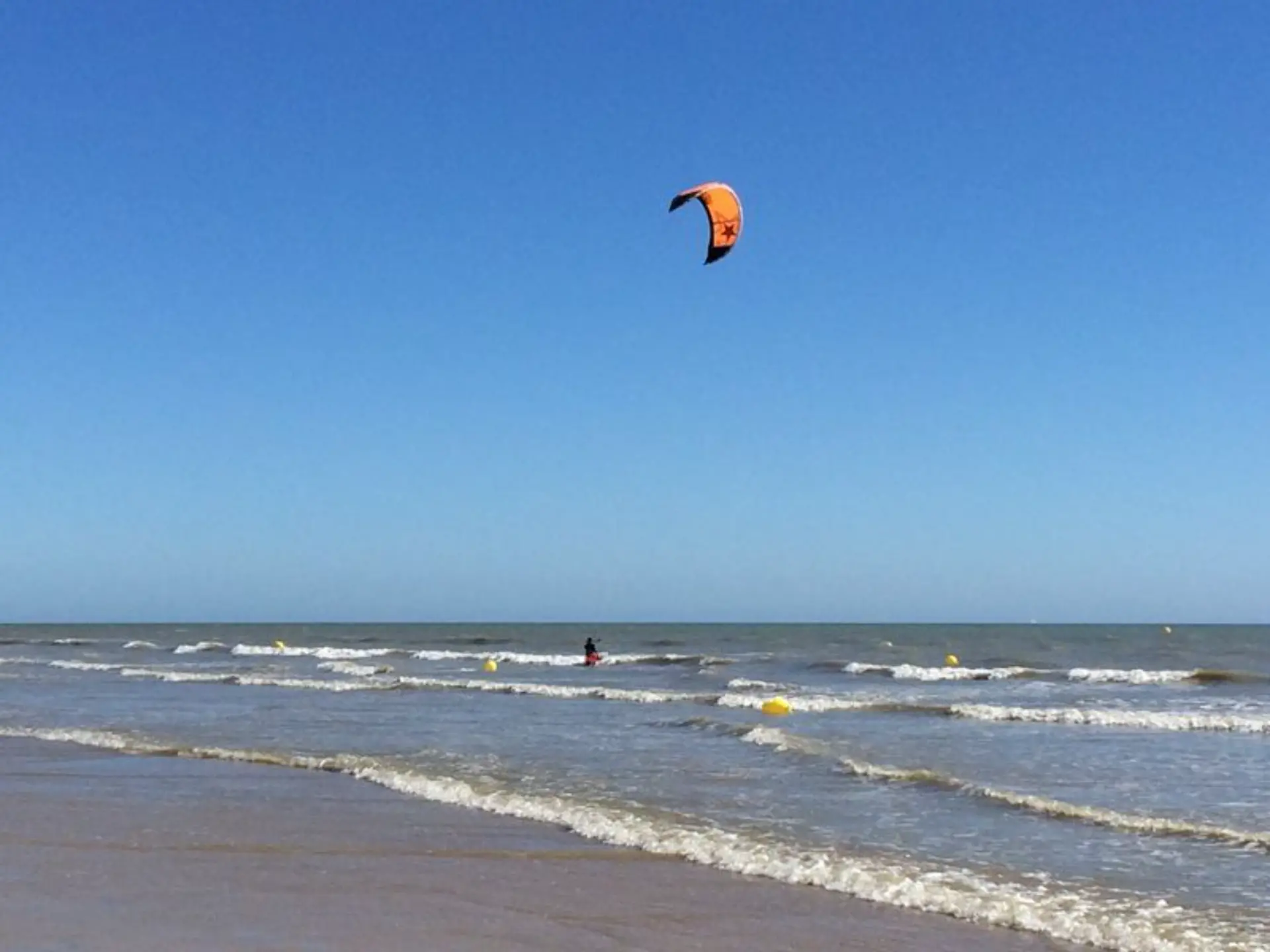 Kitesurfer sur la mer sous un ciel bleu