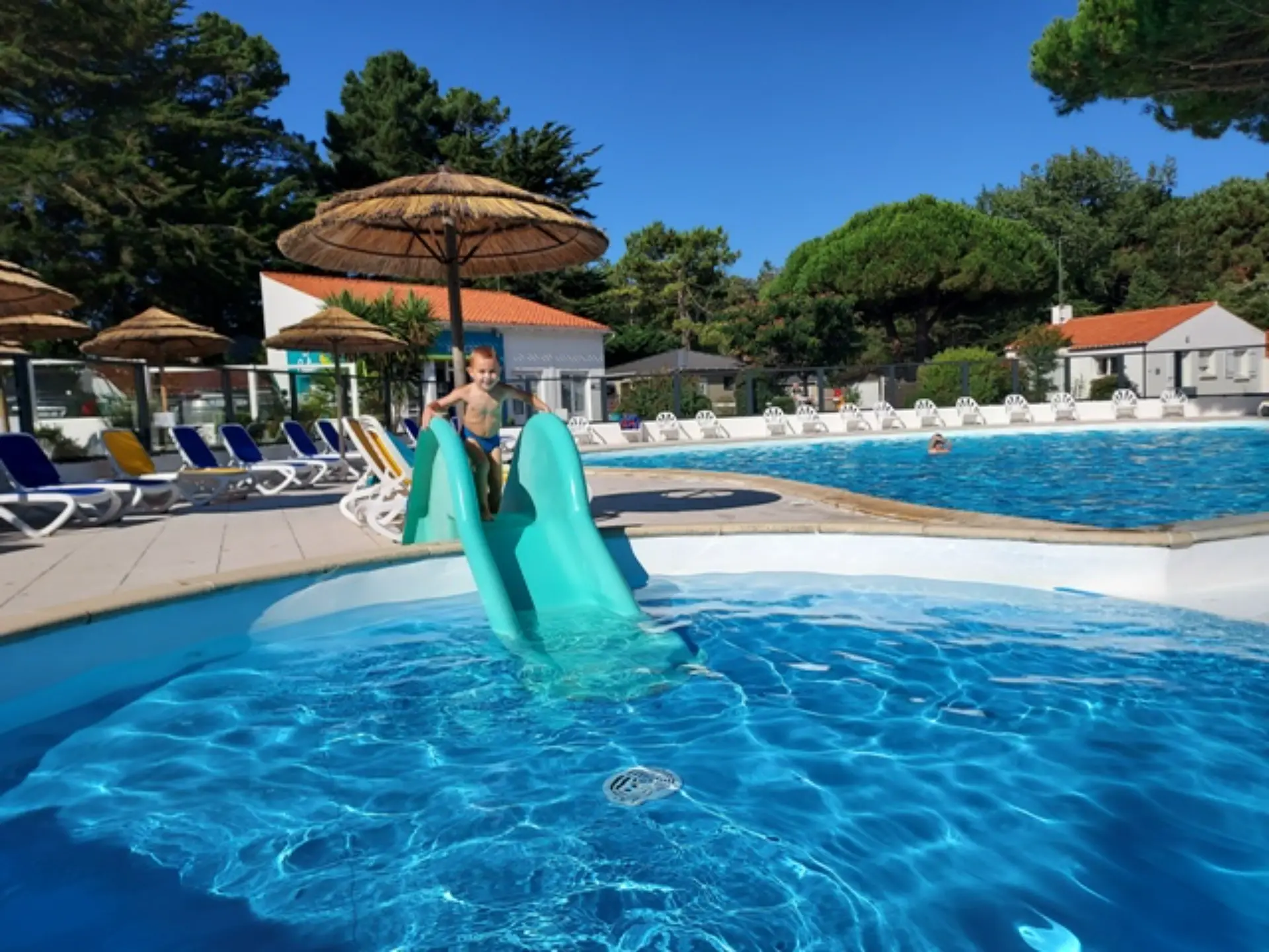 Enfant glissant sur un toboggan dans la piscine.