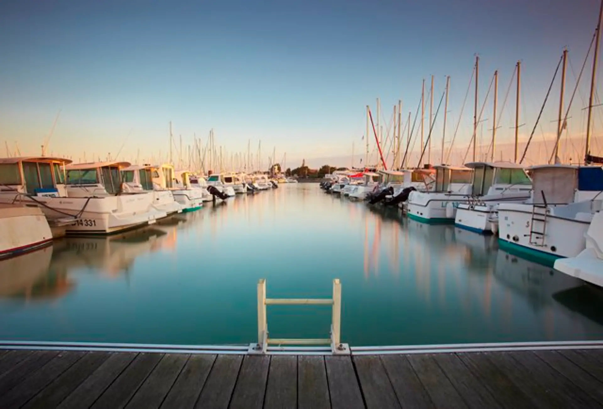 Bateaux amarrés dans un port au coucher du soleil.