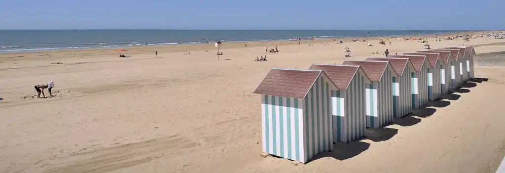 Cabines de plage alignées, bord de mer ensoleillé.